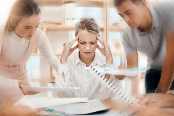 Stressed woman at desk - Data lakehouses are great for CMOs, Data Managers, and marketing teams who are overwhelmed with data