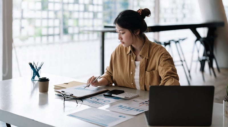 woman at desk working on budget - Viewing data as a means to secure budget is a self-defeating cycle